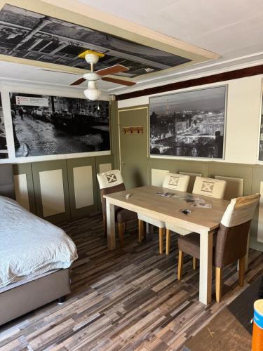 a bedroom with a table and chairs and a bed at Slotje in Egmond aan den Hoef