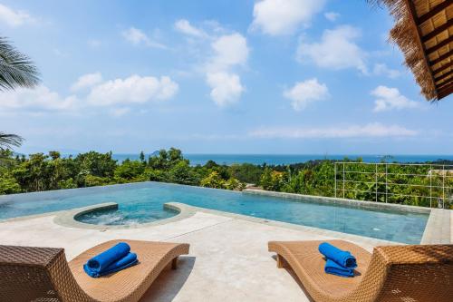 a pool with chairs and a view of the ocean at Villa Pandora in Wok Tum