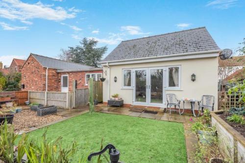 a small house with a lawn in the backyard at The Swallows Nest, Dog-Friendly Retreat with Garden in Marton
