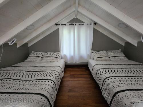 two beds in a room with a window at Enchanted Jungle Treehouse in Spanish Lookout