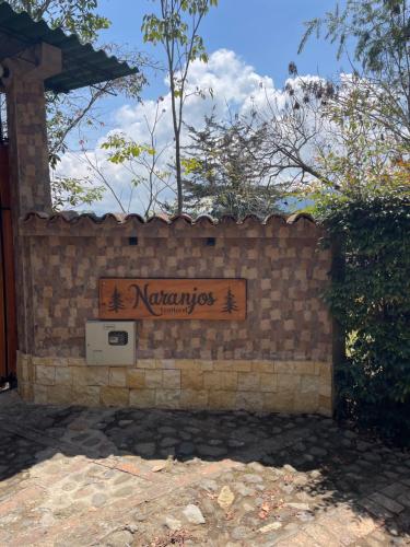 a sign on a brick wall with a sign on it at Ecohotel Naranjos in Jenesano