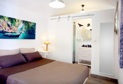 a bedroom with a bed and a bathroom with a mirror at Alojamiento Vagón Rural in Murcia