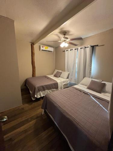 a bedroom with two beds and a ceiling fan at The Gathering Place in Spanish Lookout
