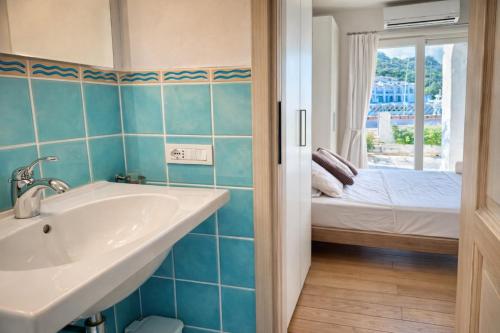 a bathroom with a sink and a bed and a window at Poltu Quatu House in Porto Cervo