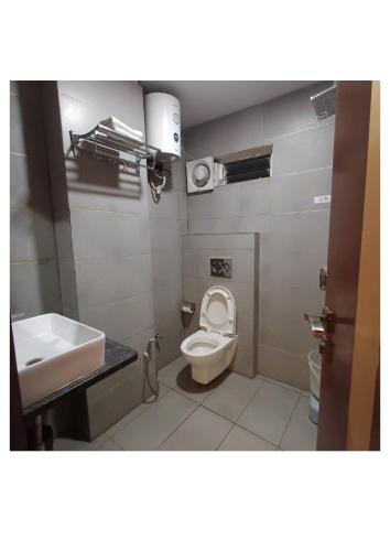 a bathroom with a toilet and a sink at Hotel Zorba in Bhopal