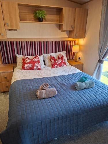 a bedroom with a bed with two towels on it at Sunningdale comfy suite in Tattershall