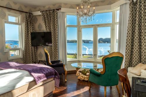 ein Schlafzimmer mit einem Bett und einem großen Fenster in der Unterkunft Hotel Wassilioff - Unike Hoteller in Stavern