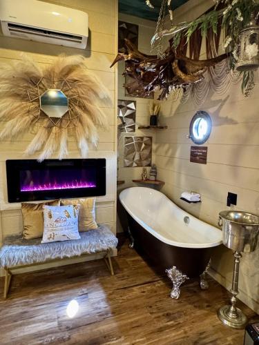 a bathroom with a tub and a clock on the wall at "Tree-T-Ment Center" Spa-Themed Luxury Treehouse with Indoor & Outdoor Soaking Tubs in Sevierville