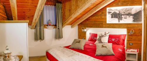 a bedroom with a red bed in a attic at Residence Villa Artic in Campitello di Fassa