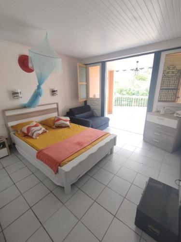 a bedroom with a bed and a living room at Joli Studio à 5 min de la plage in Sainte-Anne