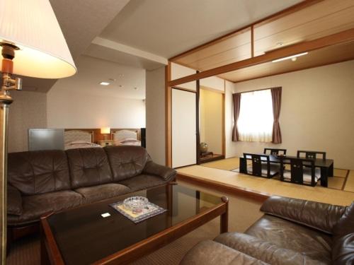 a living room with a couch and a table at Nogami President Hotel in Iizuka