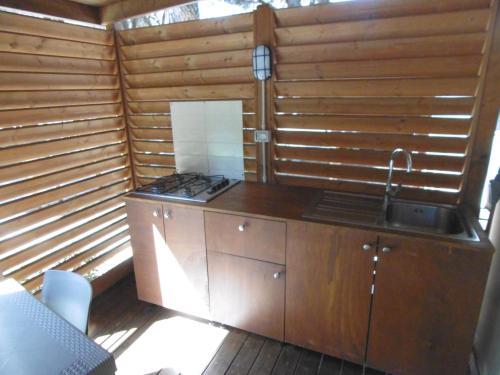 a small kitchen with a stove and a sink at Camping Eden in Marina di Grosseto