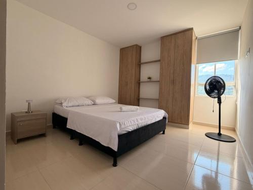 a bedroom with a bed and a fan in it at San gil plaza confort in San Gil