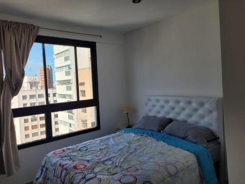 a bedroom with a bed and a large window at Depto Temporario La Plata in La Plata