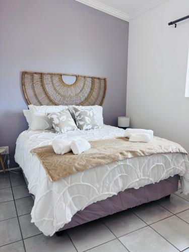 a bedroom with a large bed with white sheets and pillows at Capri Horizon Hideaway in Fish Hoek