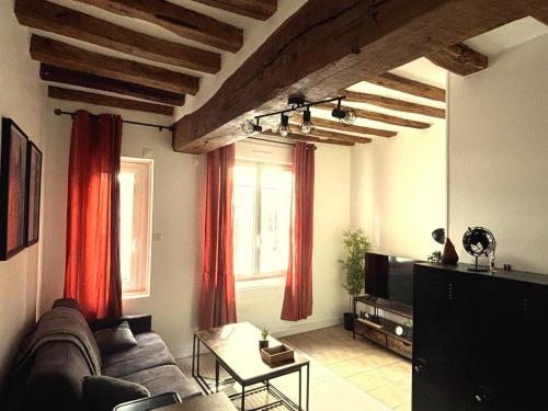 a living room with a couch and red curtains at charmant appartement 4 pers hyper centre, au calme in Rouen