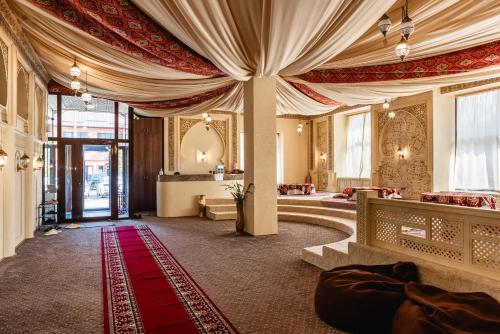 a hotel lobby with a red carpet and a large curtain at Alladin Capsule Hotel in Almaty