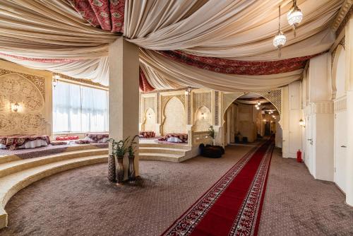 a room with a large curtain and a red carpet at Alladin Capsule Hotel in Almaty