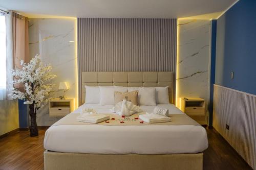 a bedroom with a large white bed with towels on it at Hotel Anddari in Arequipa