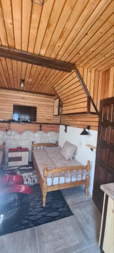 a bed in a room with a wooden ceiling at Vikendica Pejovic in Žabljak