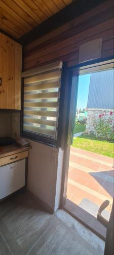a kitchen with a sliding glass door to a patio at Vikendica Pejovic in Žabljak