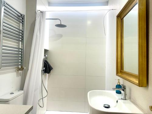 a white bathroom with a shower and a sink at VUT Plaza del Rastro in Ávila