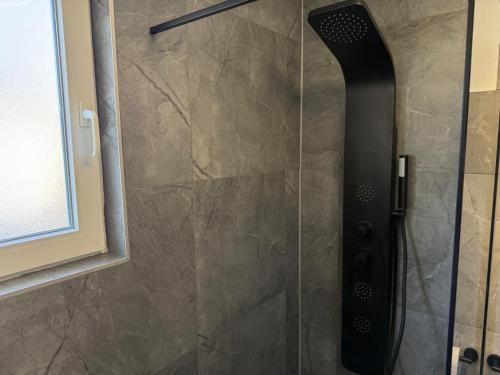 a shower with a black shower head in a bathroom at Manolo house with jacuzzi & pool in Pula