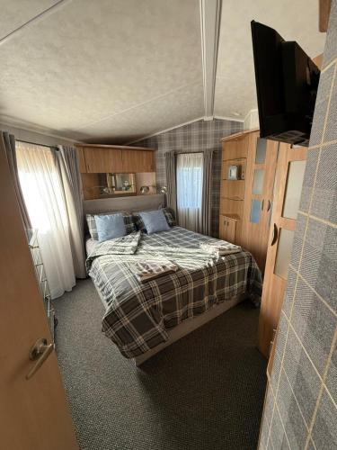 a bedroom with a bed and a flat screen tv at Summer Meadows at Sandy Bay in North Seaton