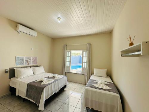 a bedroom with two beds and a window at Casa da Lua in Barreirinhas