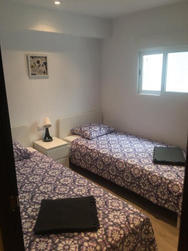 a bedroom with two beds and a window at Para, Descansa, Siente el mar - bienvenido a Cullera in Cullera