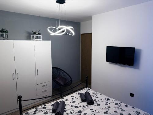 a bedroom with a bed and a white cabinet and a tv at Manolo house with jacuzzi & pool in Pula