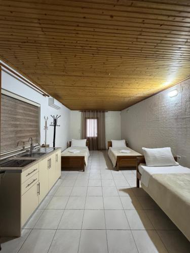 a large room with two beds and a sink at Holiday Guest-House in Përmet
