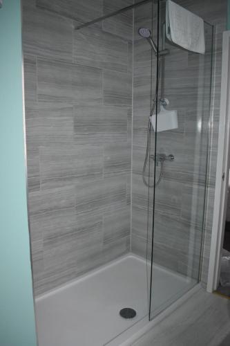 a shower with a glass door in a bathroom at The Phoenix Guest House in Scarborough