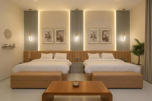 two beds in a room with two tables and a table at The Grand Elite Cairo Hotel in Cairo