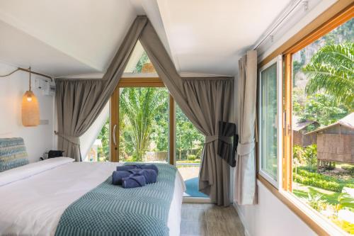a bedroom with a bed and a large window at Voasis Valley Krabi - Natural Resort - Adults Only in Ban Nong Kok (1)