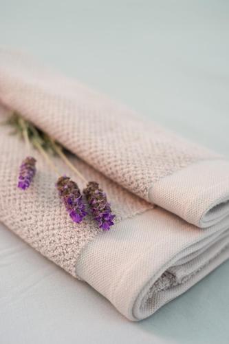 two white towels with purple flowers on them at Ria's Rest Self Catering Flatlet in Sedgefield