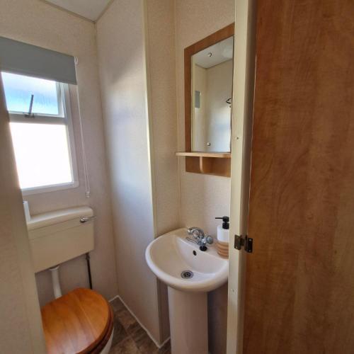 a small bathroom with a sink and a mirror at Palm Court - 3 Bed Heated Pool Parking Nr Beach in Par