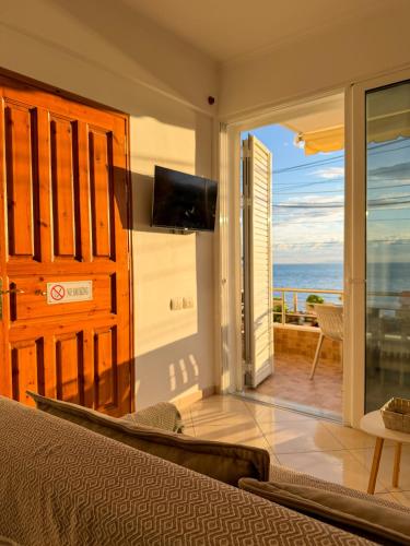 a bedroom with a bed and a view of the ocean at Fane's Apartments in Himare