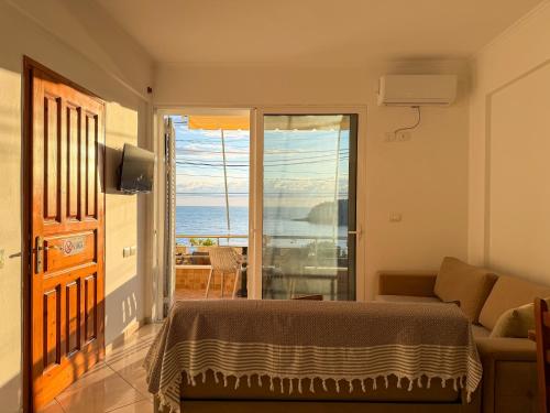 a bedroom with a bed and a view of the ocean at Fane's Apartments in Himare