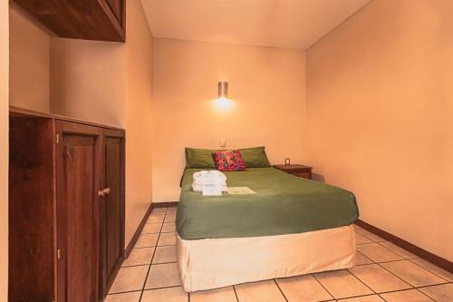 a small bedroom with a bed in a room at HOTEL NIUT-JA in Oaxaca City