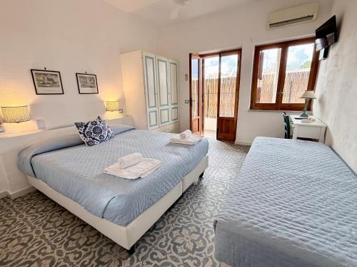 a bedroom with two beds and a window at La Giara in Vulcano