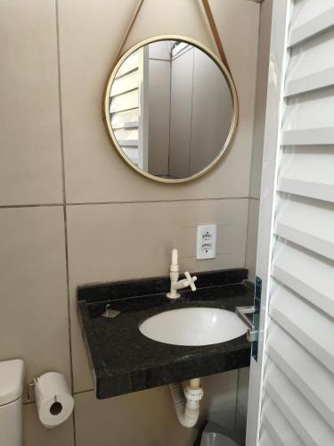 a bathroom with a sink and a mirror at Pousada Vista Verde in Paracuru