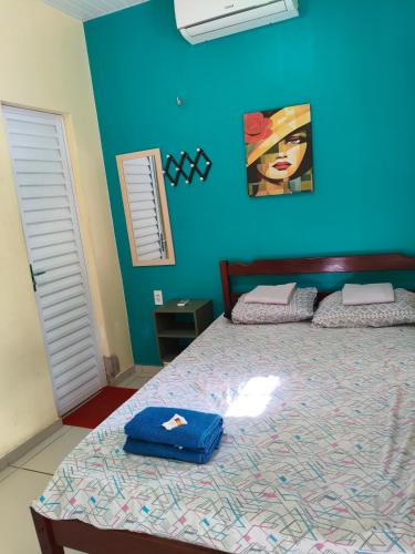 a bedroom with a bed with a blue wall at Pousada Vista Verde in Paracuru