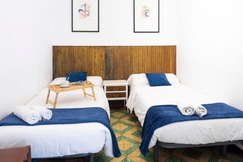 a room with three beds and a table at Casa Arbós Casa rural a Arbeca, les Garrigues in Arbeca