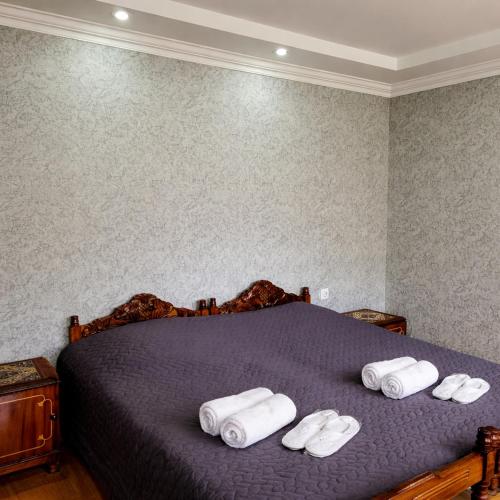 a bed with three rolled towels on top of it at Family hotel mountain panorama in Borjomi
