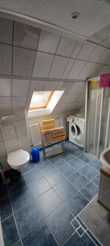 a bathroom with a toilet and a washing machine at Ferienwohnung Rita in Aschendorf
