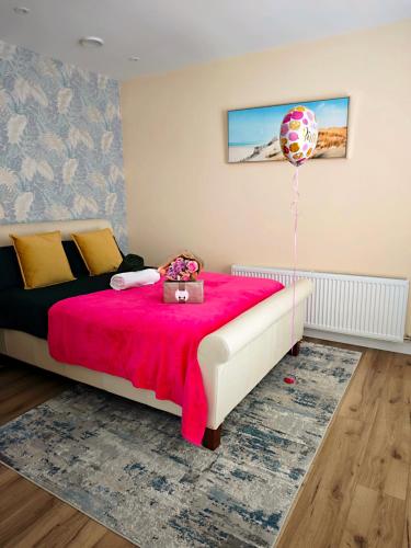 a bedroom with a bed with a pink blanket and a balloon at Ashwood Stay in Galway