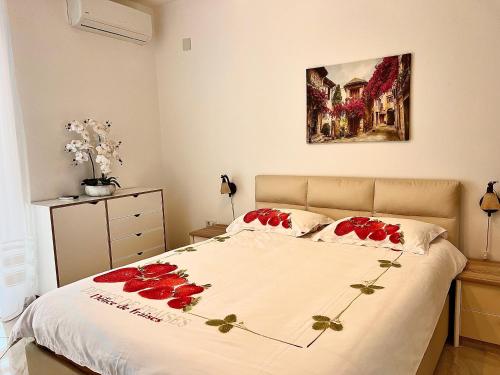 a bedroom with a bed with red roses on it at Modern Seaview Apartment with a Pool in Dobra Voda