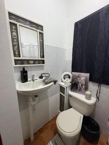 a bathroom with a white toilet and a sink at Riddim Vybz guesthouse in Kingston