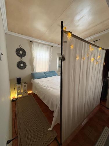 a bedroom with a white bed and a window at Riddim Vybz guesthouse in Kingston